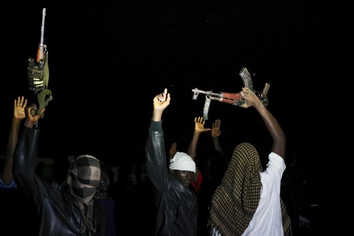 © Reuters. Armed vigilantes holds AK-47 before they patrol in the center of Bujumbura, Burundi