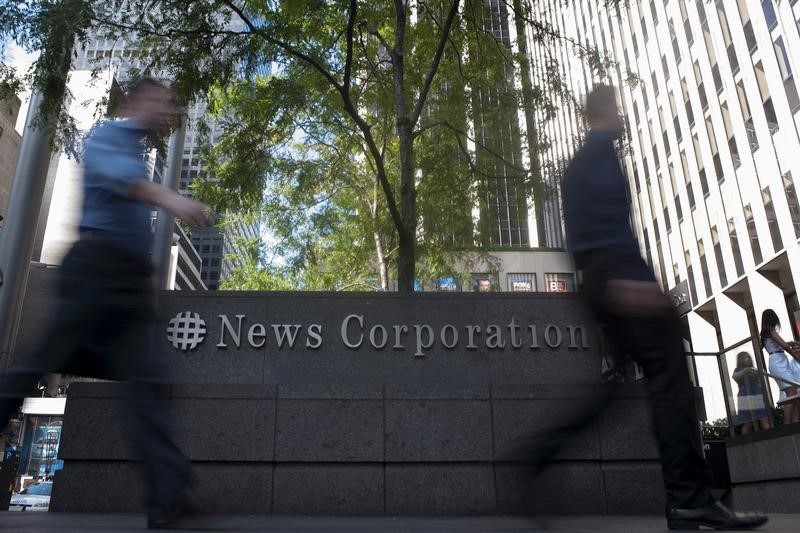 © Reuters. Passers-by walk near the News Corporation building in New York