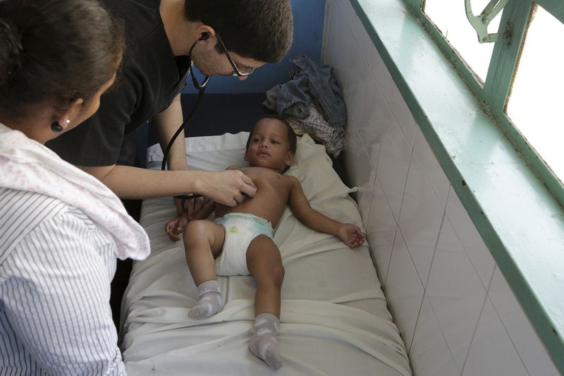 © Reuters. A child suspected to be infected with Zika virus is being examined by a doctor at the emergency room in a hospital at the Petare slum in Caracas