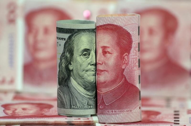 © Reuters. A Benjamin Franklin U.S. 100-dollar banknote and a Chinese 100-yuan banknote depicting the late Chinese Chairman Mao Zedong, are seen in a picture illustration in Beijing