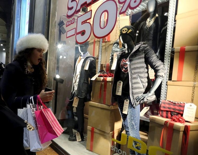 © Reuters. Una donna davanti ad una vetrina a Milano 