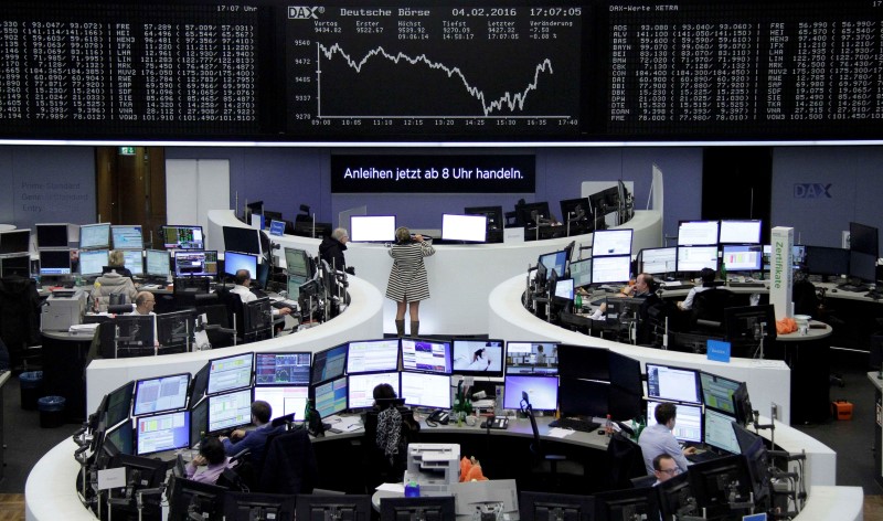 © Reuters. Traders work at their desks in front of DAX board at Frankfurt stock exchange