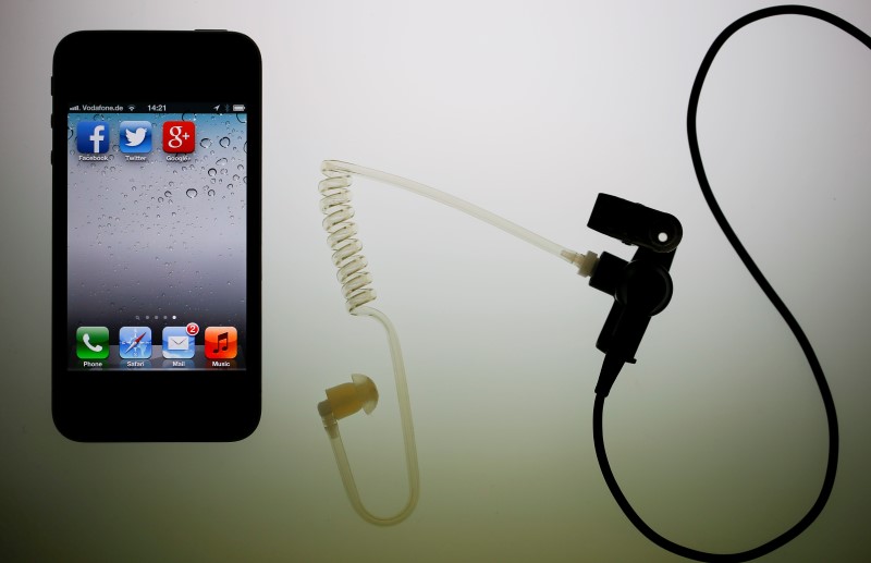 © Reuters. Illustration picture of application icons of Facebook Twitter and Google on iPhone next to earphone set in Berlin