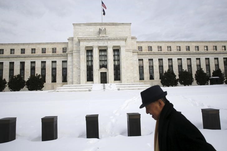 © Reuters. A man walks past the snow-covered grounds of the U.S. Federal Reserve in Washington