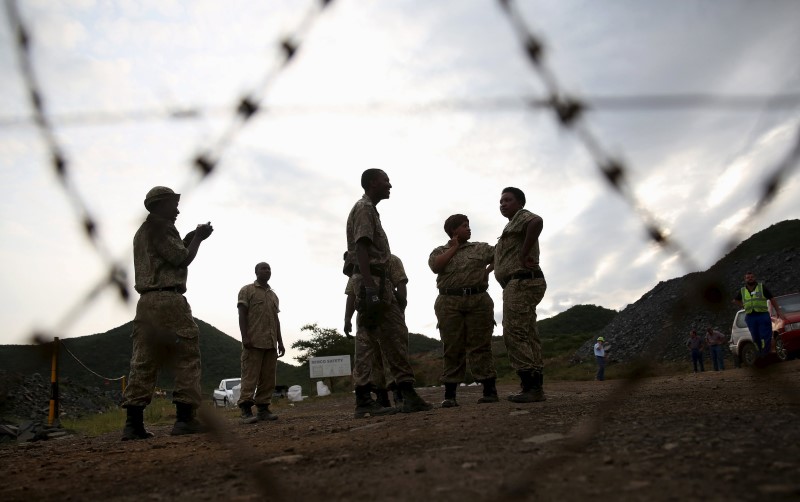 © Reuters. Security guards keep watch at the entrance of the Lily mine near Barberton