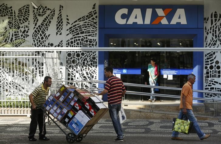 © Reuters. Pessoas caminham em frente a uma agência da Caixa Econômica Federal no centro do Rio de Janeiro