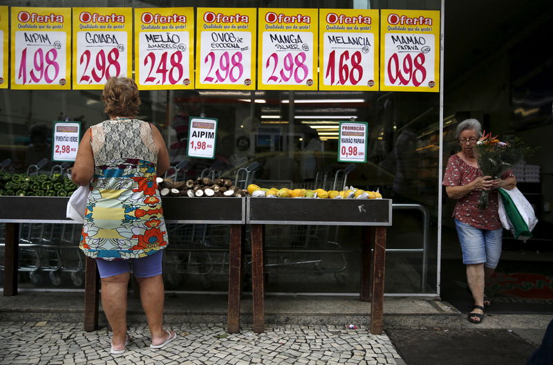 © Reuters. Mulher observa placas com preços de alimentos em mercado no Rio de Janeiro