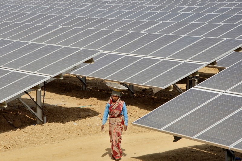 © Reuters. A worker walks through the installed solar modules at Naini solar power plant in Allahabad