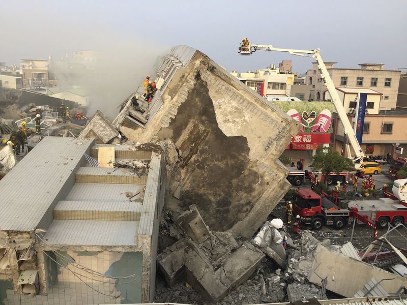 © Reuters. Спасатели ищут выживших после обрушения жилого дома в Тайнане 