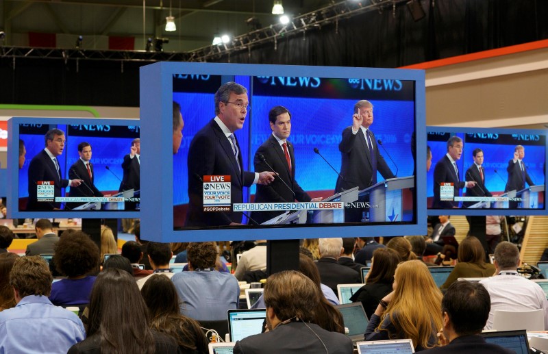 © Reuters. Republican U.S. presidential candidates Trump and Bush speak as journalists watch the debate in the media center during the Republican U.S. presidential candidates debate sponsored by ABC News at Saint Anselm College in Manchester
