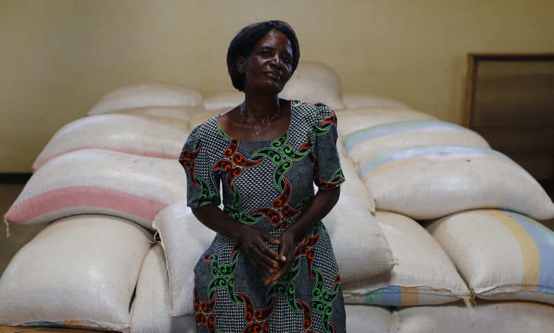 © Reuters. Subsistence farmer Salome Banda stands beside bags of her maize stacked in a warehouse north of Lilongwe