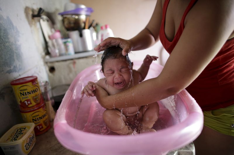 © Reuters. Rosana Vieira Alves bathes her 4-month-old daughter Luana Vieira, who was born with microcephaly, at their home in Olinda