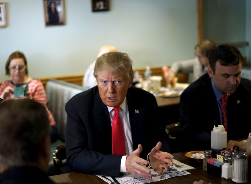 © Reuters. U.S. Republican presidential candidate Trump talks with staff at the Chez-Vauchon restaurant in Manchester