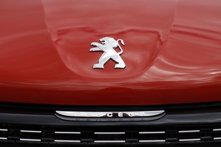 © Reuters. A logo is pictured on a Peugeot 208 car parked at the PSA Peugeot Citroen plant in Poissy, near Paris