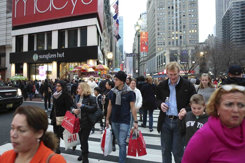 © Reuters. File photo of a man in short sleeves carrying shopping bags near Herald Square during unseasonably warm weather in Manhattan