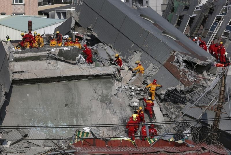 © Reuters. Rescue personnel search the rubble of a 17-storey apartment building that collapsed after an earthquake hit Tainan