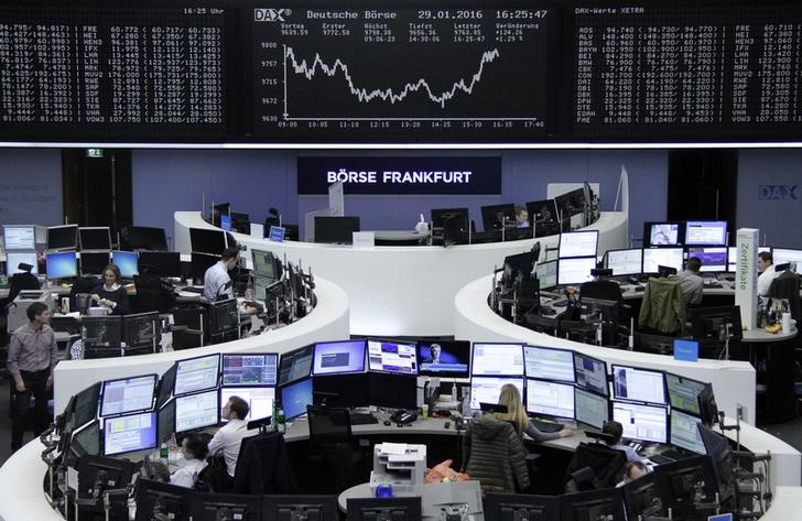 © Reuters. Traders work at their desks in front of the German share price index, DAX board, at the stock exchange in Frankfurt