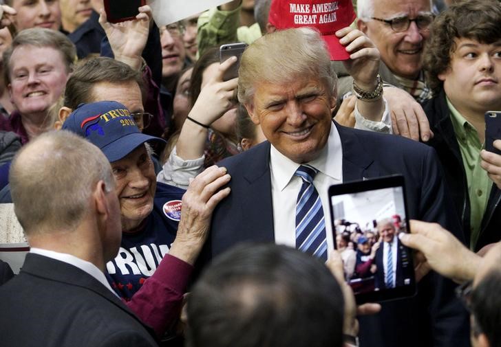 © Reuters. U.S. Republican presidential candidate Trump poses for a photo with a supporter after a campaign rally in Plymouth