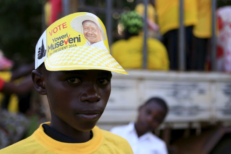 © Reuters. A boy wears a National Resistance Movement (NRM) party hat of Uganda President and presidential candidate Yoweri Museveni in Masindi town