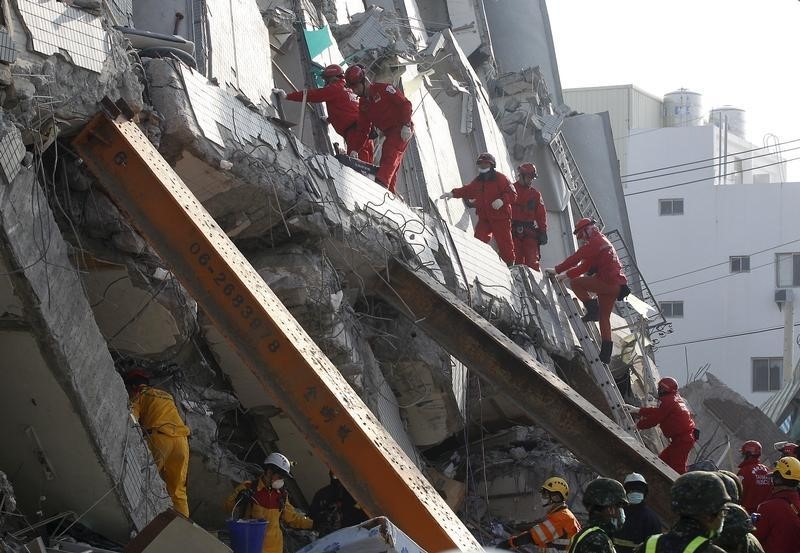 © Reuters. Rescue personnel work at the site where a 17 story apartment building collapsed from an earthquake in Tainan