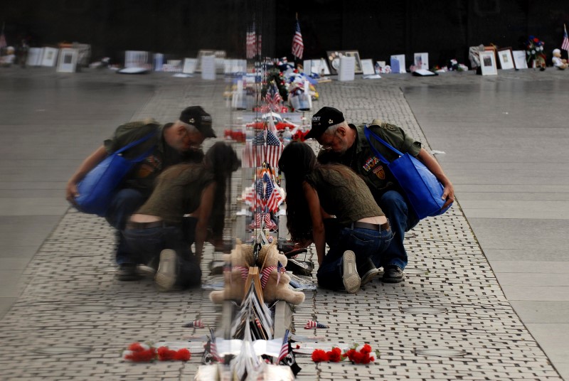 © Reuters. File photo of visitors examining items left at the base of the Vietnam Veterans Memorial in Washington