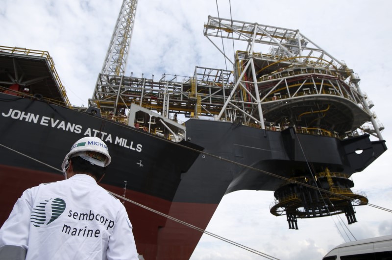 © Reuters. A Sembcorp employee stands near the turret of Tullow Oil's newly completed Floating Production, Storage and Offloading vessel (FPSO) Prof. John Evans Atta Mills at Sembcorp Marine's Jurong Shipyard in Singapore 