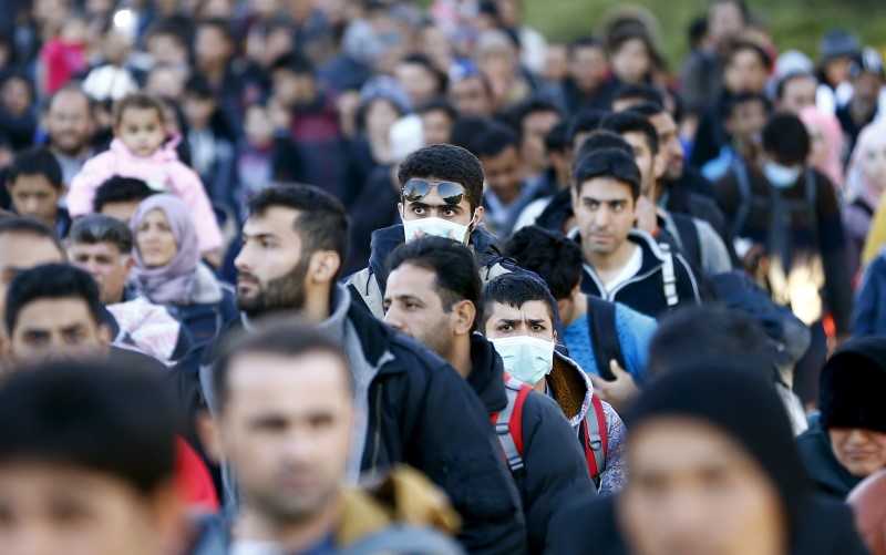 © Reuters. Migrants walk towards the Austrian border town of Spielfeld in the village of Sentilj