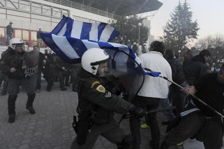 © Reuters. A Greek farmer hits a riot police officer with a Greek flag during a demonstration against planned pension reforms in the northern city of Thessaloniki