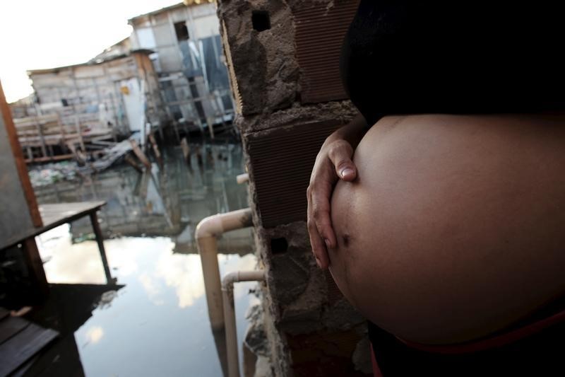 © Reuters. Patricia Araujo, 23, who is seven months pregnant, stands in front of her stilt house, a lake dwelling also known as palafitte or 'Palafito', in Recife