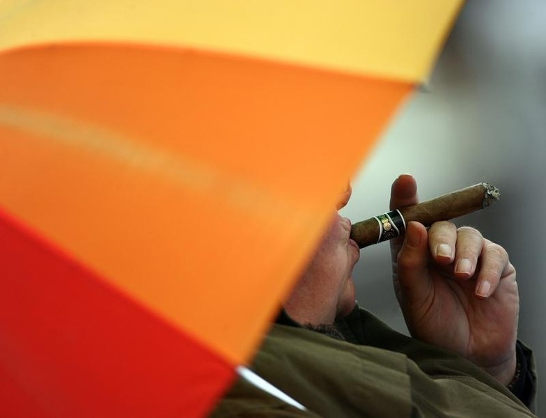 © Reuters. Зритель крикетного матча между сборными Англии и Шри-Ланки курит сигару