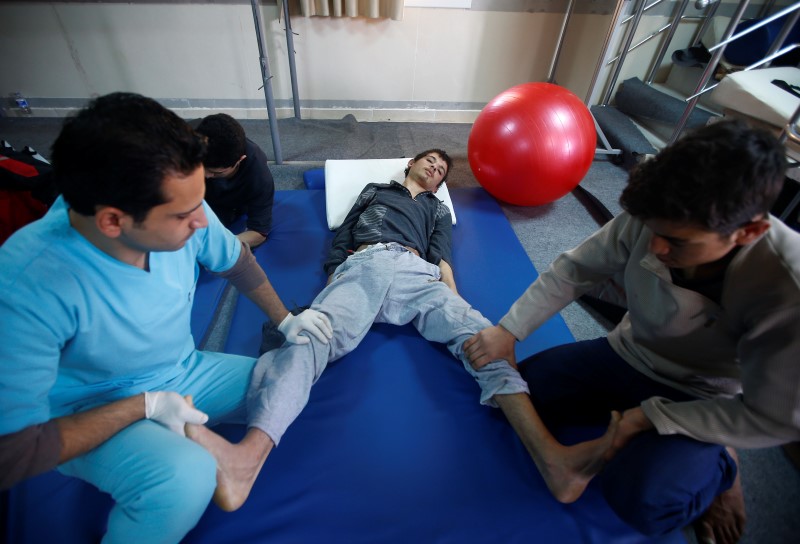 © Reuters. An injured Syrian man receives physical therapy at a small clinic near the Turkish-Syrian border in the southeastern city of Kilis