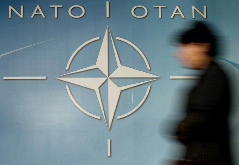 © Reuters. A WOMAN WALKS PAST THE NATO LOGO IN BRUSSELS.