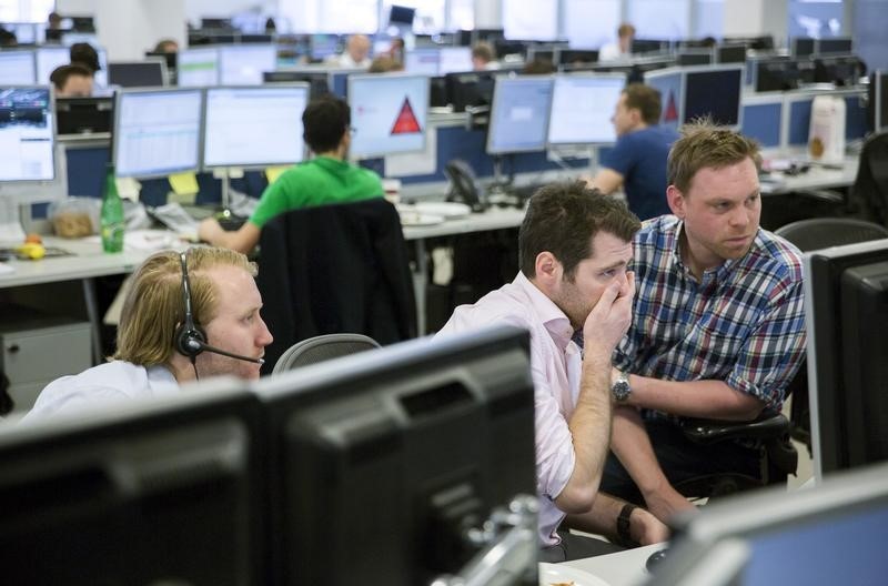 © Reuters. Dealers react as they work on the IG Group trading floor in London, Britain