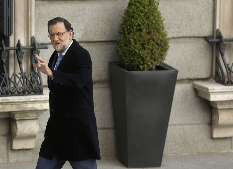 © Reuters. Spanish acting PM Rajoy gestures as he arrives for a meeting with fellow party deputies at the Parliament in Madrid