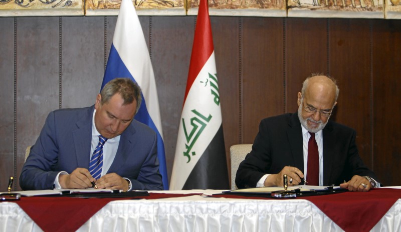 © Reuters. Iraqi Foreign Minister Ibrahim al-Jaafari (R) and Russia's Deputy Prime Minister Dmitry Rogozin (L) sign documents in Baghdad