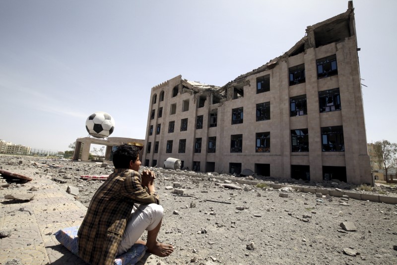 © Reuters. Houthi militant sits amidst debris from the Yemeni Football Association building, which was damaged in a Saudi-led air strike, in Sanaa