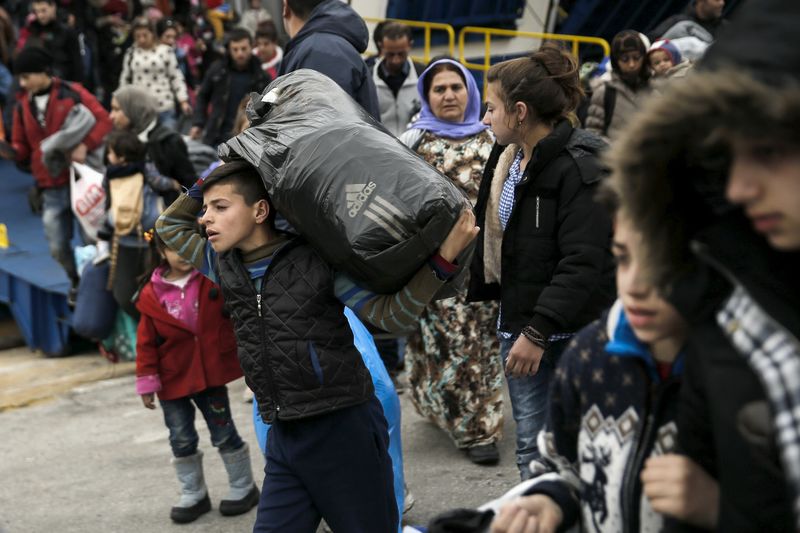 © Reuters. Refugees and migrants arrive aboard the Tera Jet passenger ship at the port of Piraeus