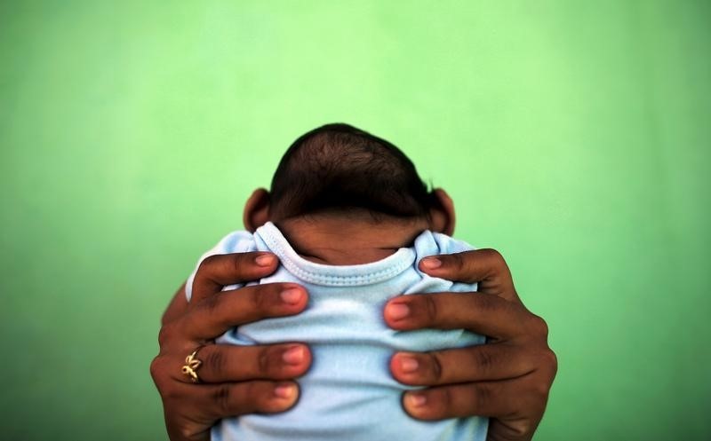© Reuters. Jackeline, de 26 anos, segura o filho Daniel, de 4 meses, que nasceu com microcefalia em Olinda