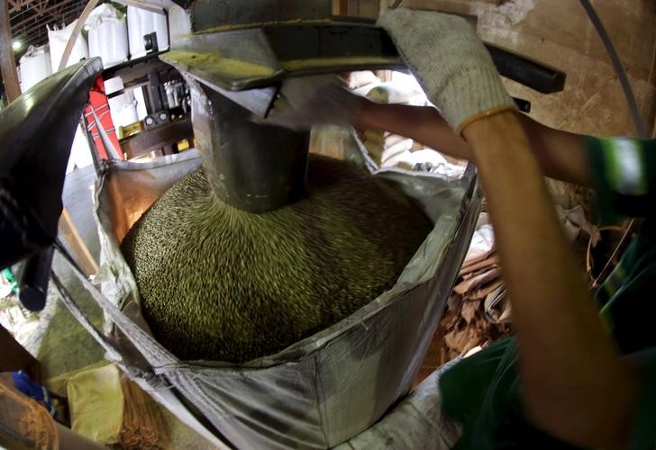 © Reuters. Trabalhador enche saca de café para exportação no porto de Santos