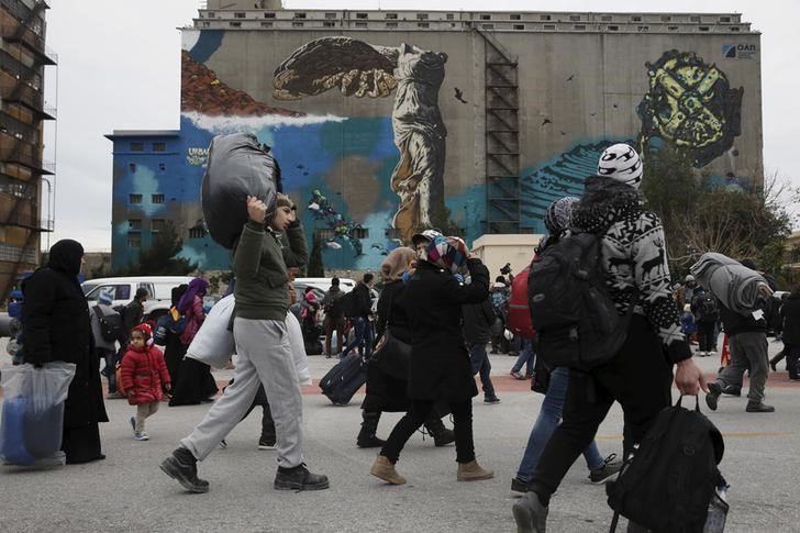 © Reuters. Refugiados e imigrantes após desembarcarem no porto de Piraeus, na Grécia