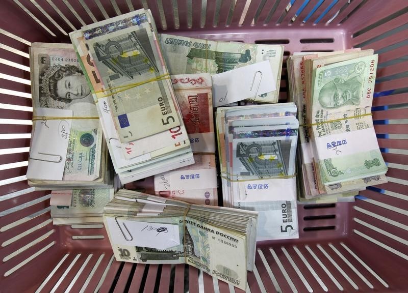 © Reuters. Foreign currency banknotes are placed on a basket for counting during a photo opportunity at the bank's headquarters in Seoul