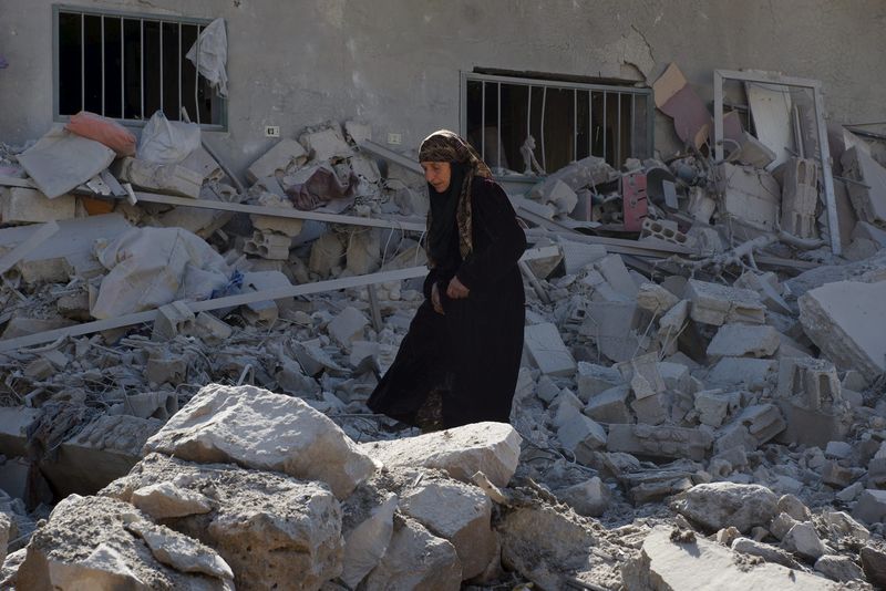 © Reuters. Mulher em meio a destroços na cidade síria de Dael, em Deraa Governorate