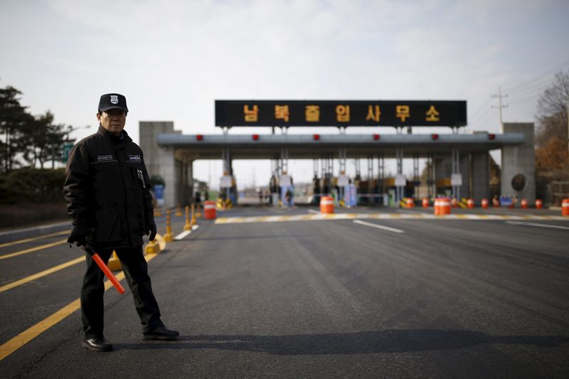 © Reuters. A South Korean security guard stands guard on an empty road which leads to the Kaesong Industrial Complex (KIC) at the South's CIQ, in Paju