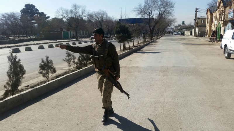 © Reuters. An Afghan policeman keeps watch at the site of a suicide bomb attack in Kabul