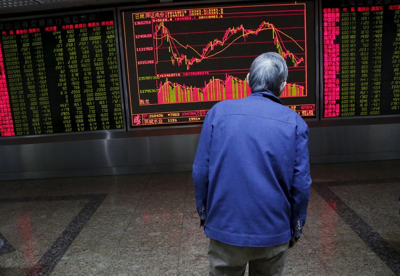 © Reuters. An investor watches an electronic board showing stock information on the first trading day after the week-long Lunar New Year holiday at a brokerage house in Beijing