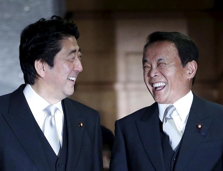 © Reuters. Japan's Prime Minister Abe and Japan's Deputy Prime Minister and Finance Minister Aso smile together as they prepare for a photo session at his official residence in Tokyo 