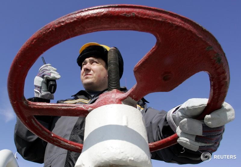 © Reuters. Рабочий Роснефти поворачивает вентиль на нефтедобывающей станции недалеко от Нефтеюганска