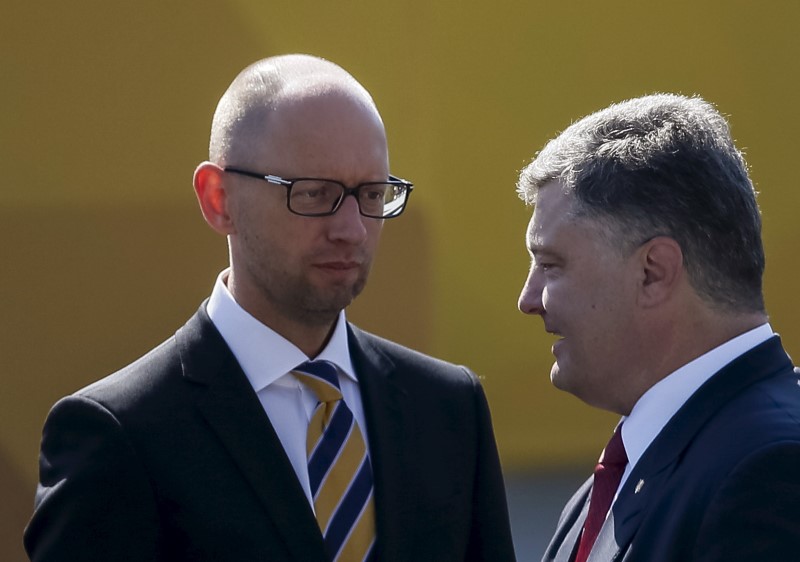 © Reuters. Ukraine's President Poroshenko speaks with Prime Minister Yatseniuk after the Independence Day military parade, in the center of Kiev