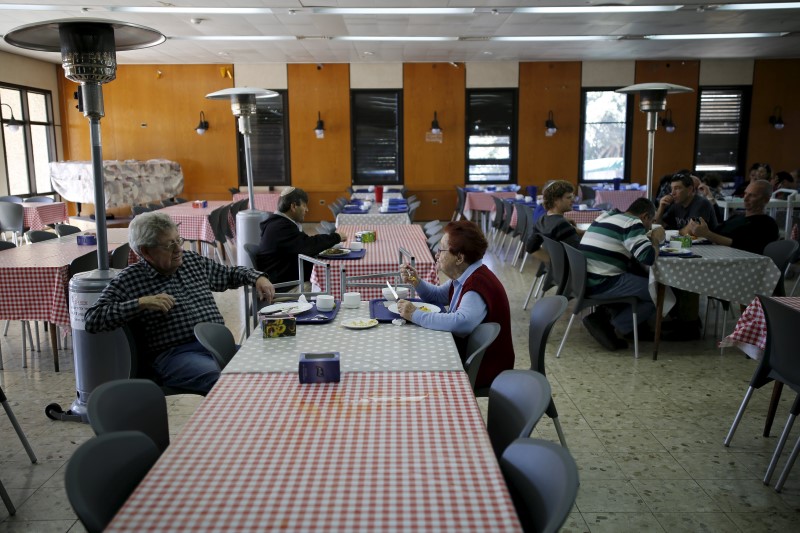 © Reuters. Israelis eat in the dining hall of Kibbutz Shaar Haamakim in northern Israel 