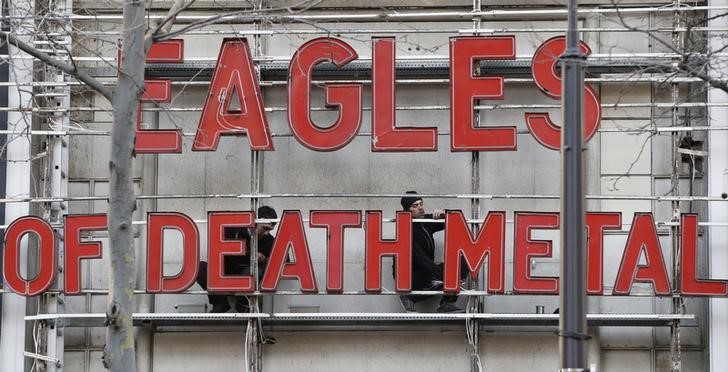 © Reuters. Homens colocam letras da banda Eagles of Death Metal em Paris